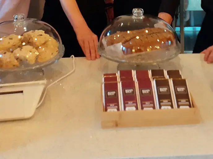 The café counter with cakes under glass domes and a box of chocolate bars.